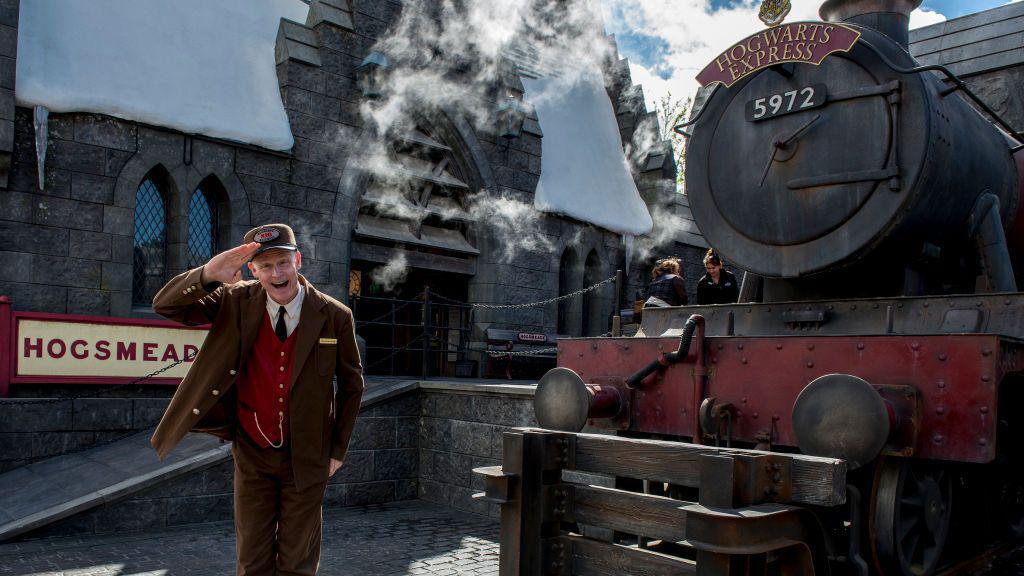 A man salutes outside the Hogwarts Express in Universal Studios Hollywood