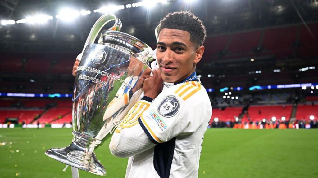 jude bellingham holding champions league cup