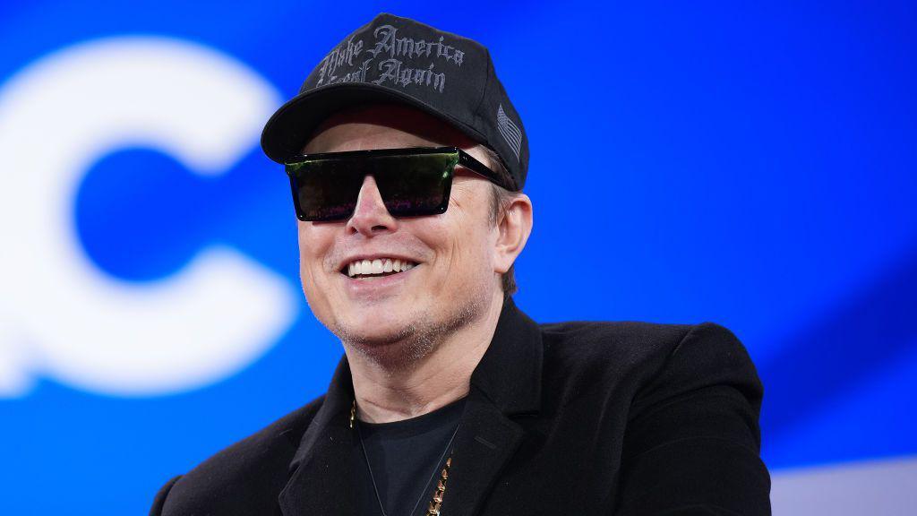 Elon Musk wears a Make America Great Again black hat