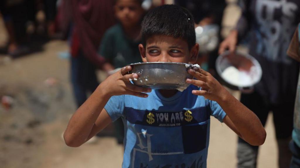 A boy eating food from a bowl