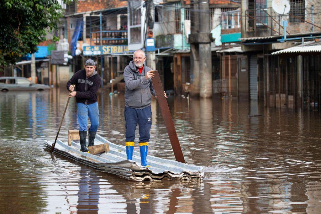 Two men paddle a makeshift canoe down a flooded street in Porto Alegre, Brazil