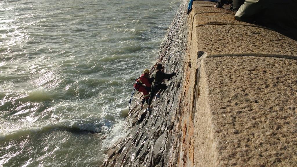 Firefighters rescuing teenagers cut off by the tide