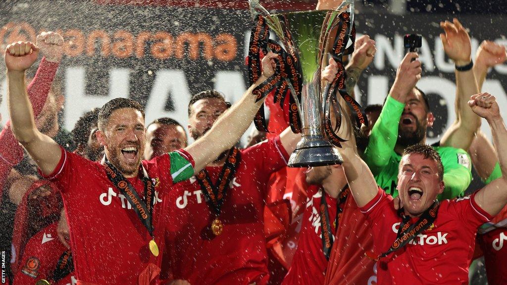 Ben Tozer lifts the National League trophy with Luke Young