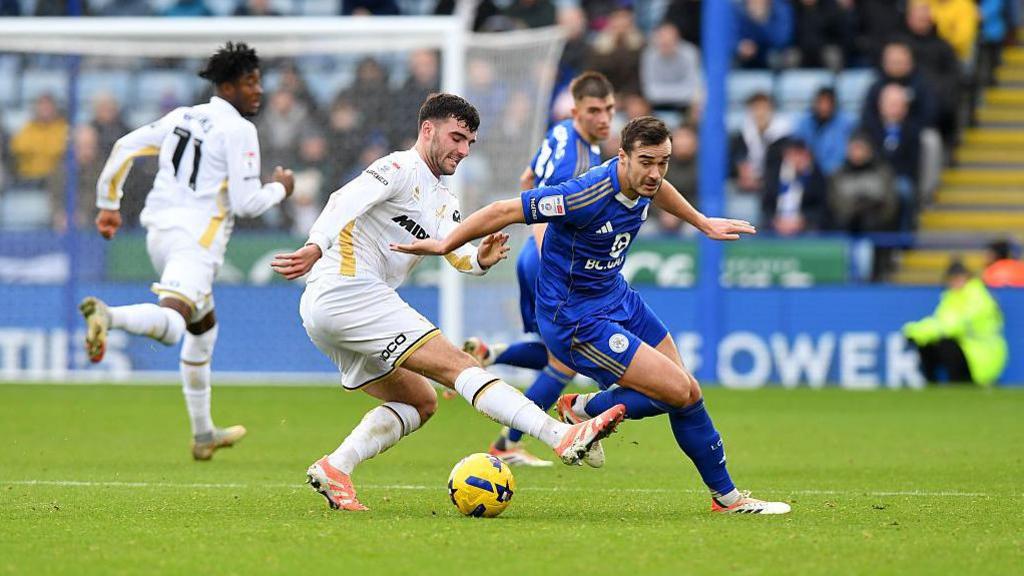 Sheffield United's Tom Cannon battles Harry Winks of Leicester City for possession.
