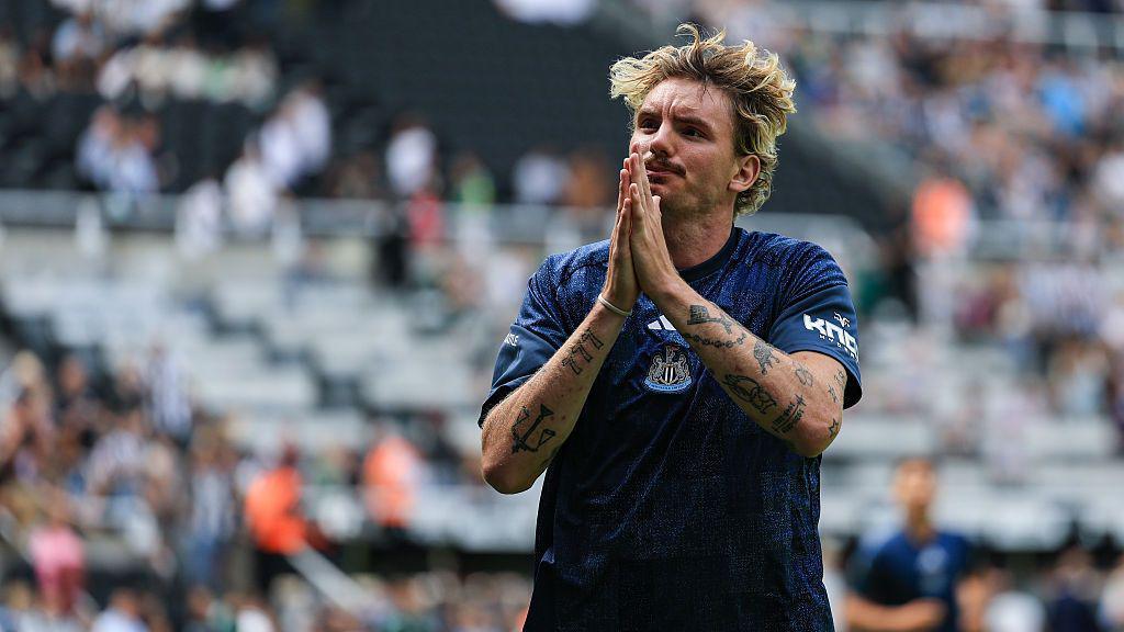 Nick Woltemade with his hands together in a gesture to fans during a warm-up at St James' Park
