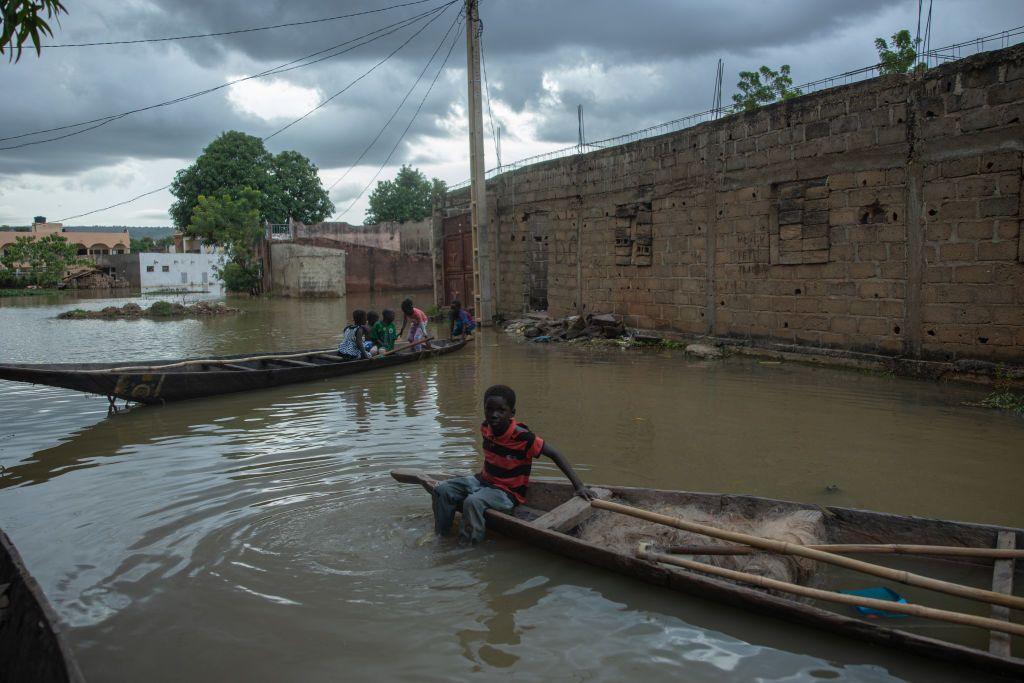 Boys sit on pirogues in the flooded area of the Kalaban Koro district in Bamako - Wednesday 2 October 2024