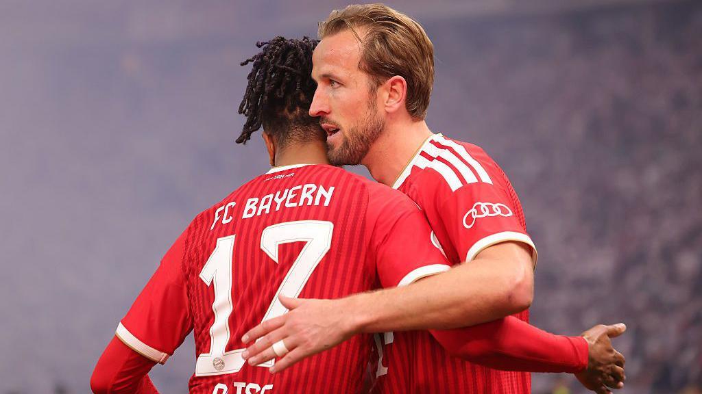 Harry Kane is hugged by Bayern team-mate Michael Olise
