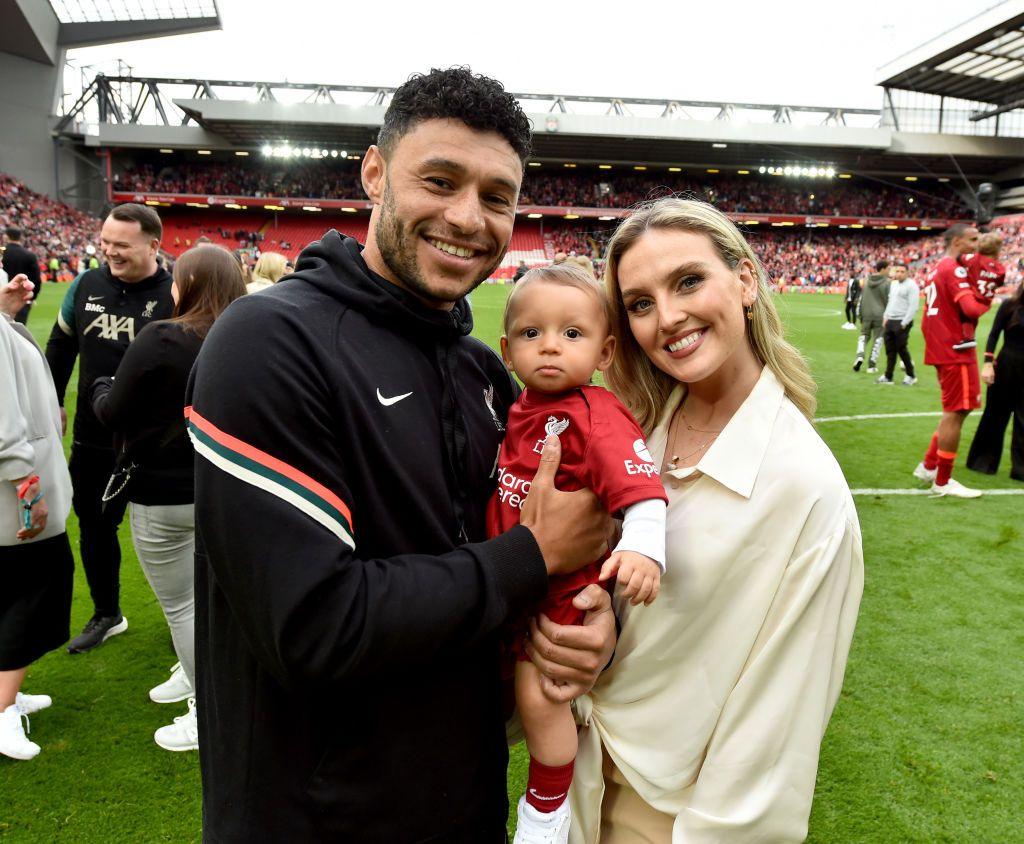 Perrie Edwards and Alex Oxlade-Chamberlain pose with their baby son on a football pitch in 2022