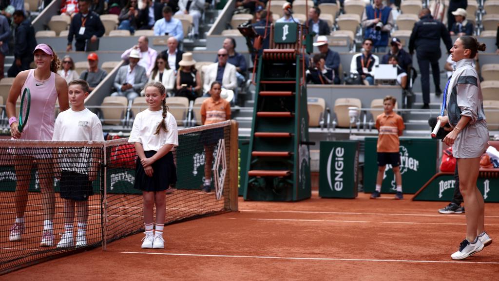 Mirra Andreeva poses for a photo as Marta Kostyuk warms up before their French Open semi-final