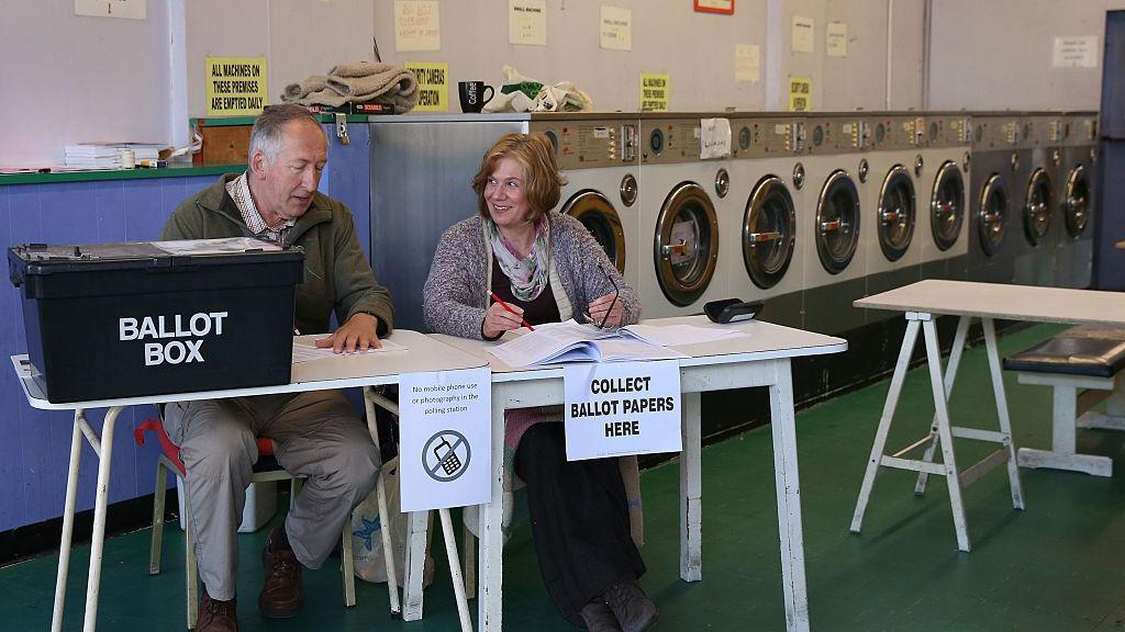 two people at polling station in laundrette