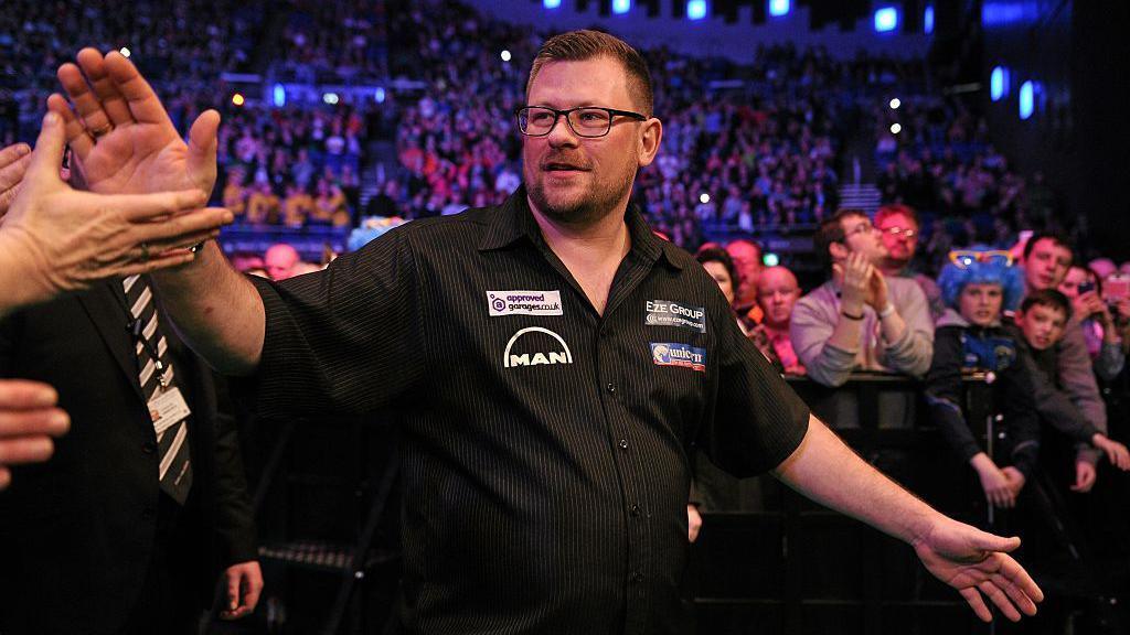 James Wade enters the stage ahead of his match against Peter Wright during the Premier League Darts