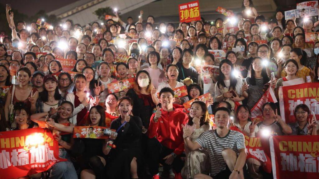 Swimmer Sun Yang poses for a group photo with fans after winning the Men's 400m Freestyle Final on day one of the 2024 National Summer Swimming Championships.