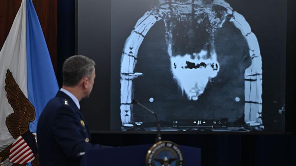General Caine looking ad picture of bunker buster bomb impact