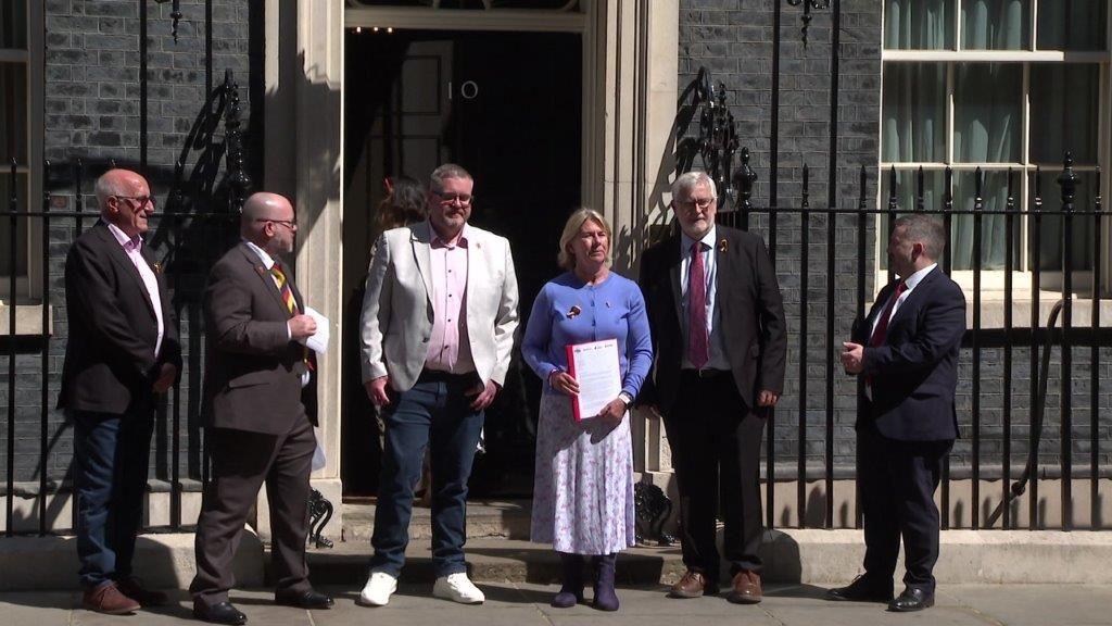 Campaigners stand on steps of 10, Downing Street with their letter to the Prime Minister
