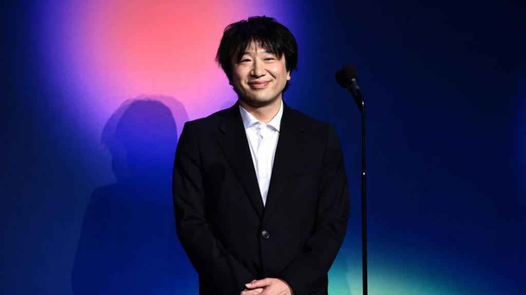 Shigetaka Kurita, inventor of the emoji in front of a microphone at the webby awards in 2023