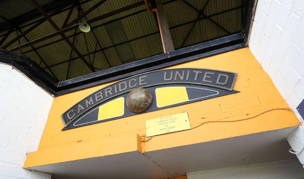 A metal name plate says Cambridge United with a bronze sculpture of an old fashioned ball beneath