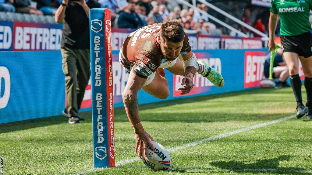 Tommy Makinson takes to the air to score in the corner for St Helens