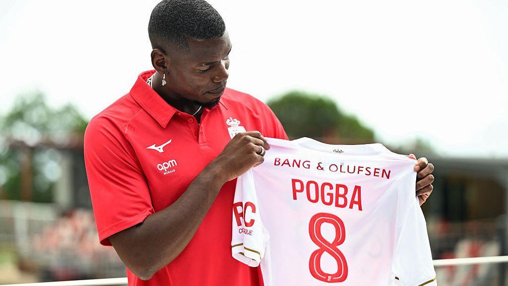 Paul Pogba holds a number 8 shirt