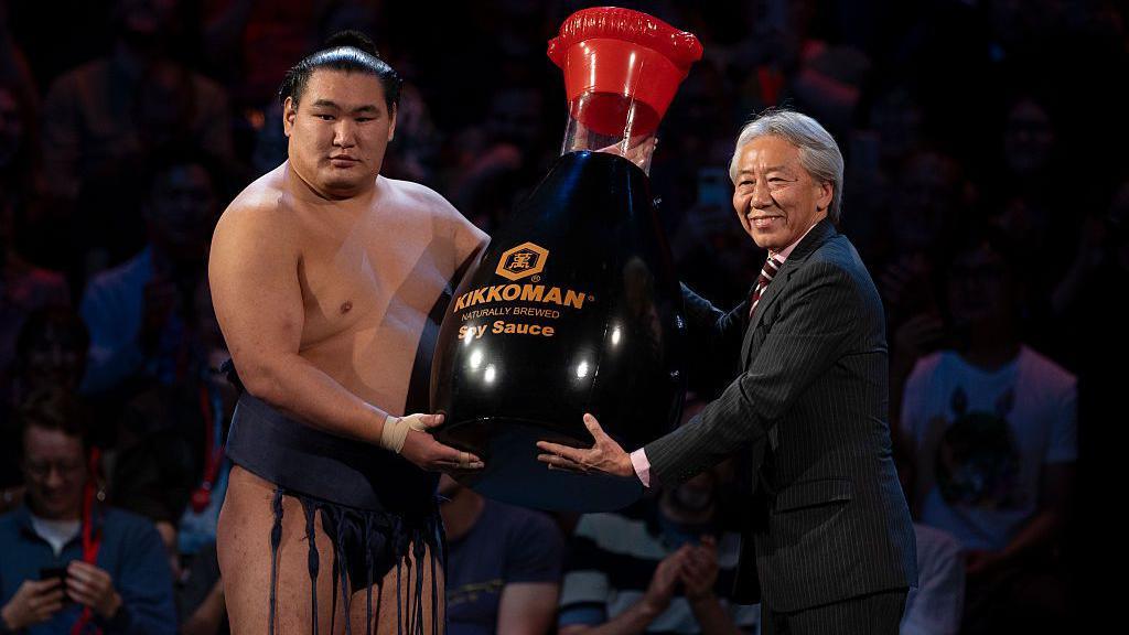 Hoshoryu Tomokatsu is presented with a giant bottle of soy sauce