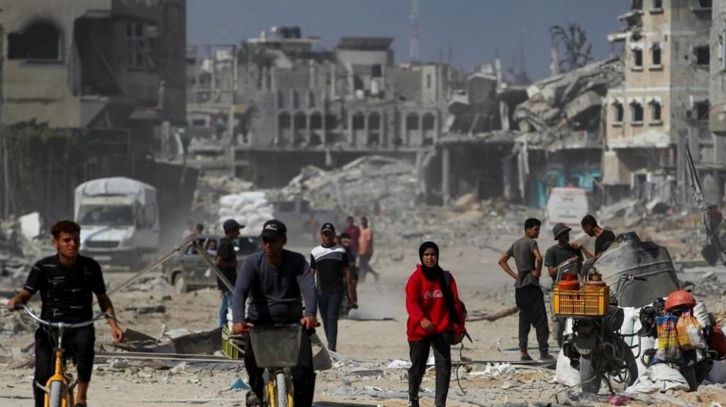 Damage in Khan Younis with Palestinians in the foreground