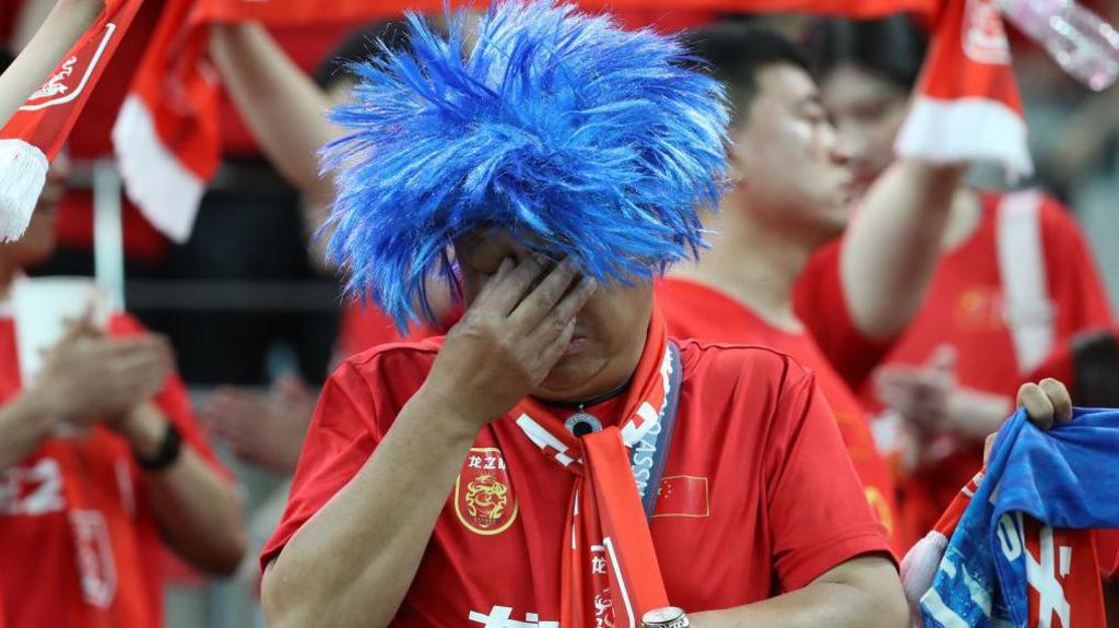 A south korea fan with his head in his hands