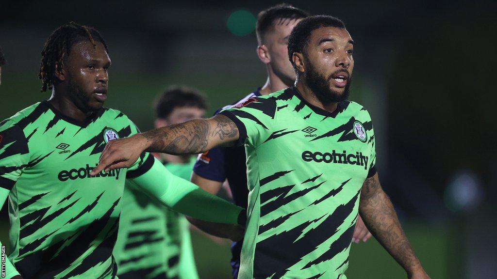 Troy Deeney points with his arm out during a Forest Green game