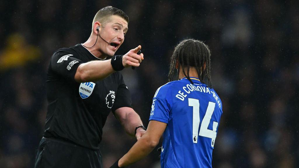 Referee John Brooks speaks to Bobby Decordova-Reid of Leicester City 