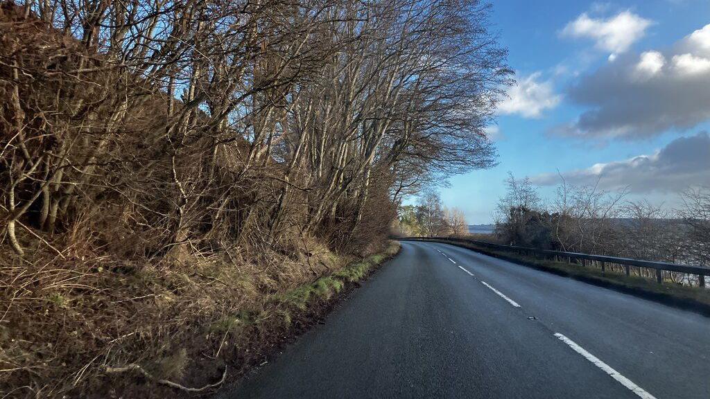Rathad an A862 faisg air Àird Ilidh. Rathad teàrr le loidhnichean geala sa mheadhan. Tha craobhan air gach taobh dhiubh gun duilleagan orra.