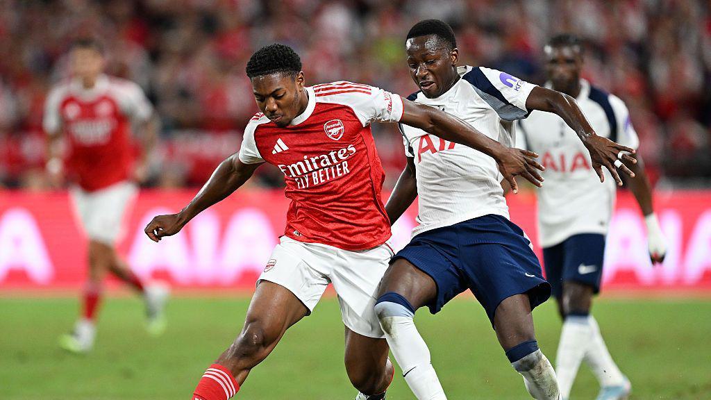 Arsenal's Myles Lewis-Skelly is challenged by Tottenham's Pape Matar Sarr