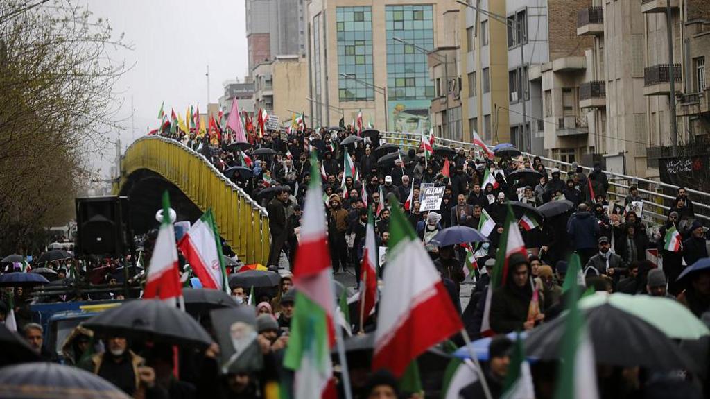 A crowd of pro-establishment demonstrators flows over a bridge in Tehran, Iran