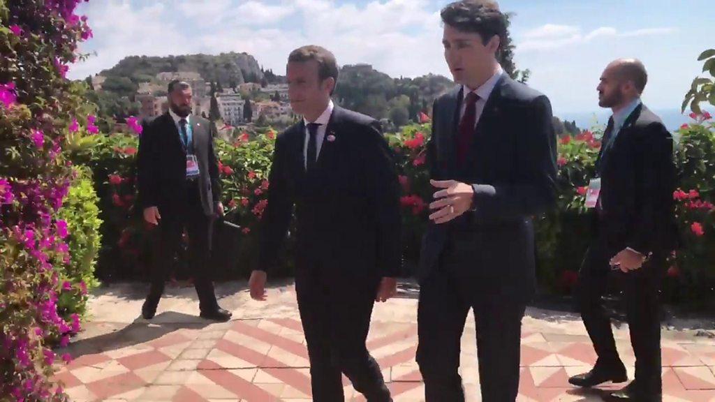 Emmanuel Macron and Justin Trudeau chat as they walk through a garden at the G7 summit