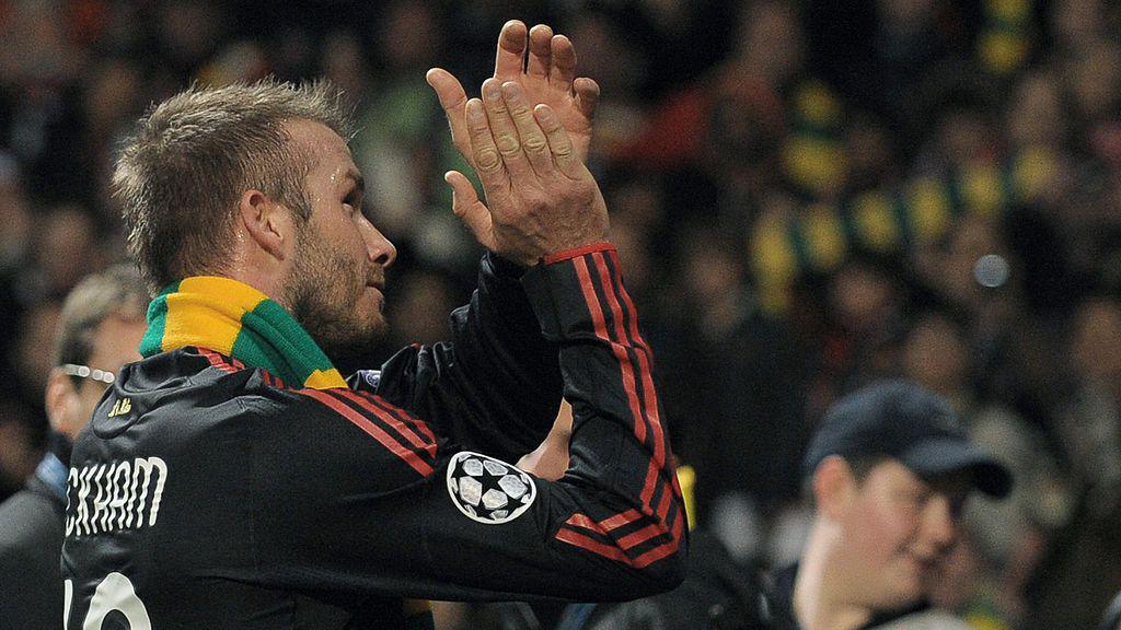 AC Milan's David Beckham wears the gold and green scarf as he applauds Manchester United fans after their CHampions League match at Old Trafford in 2010