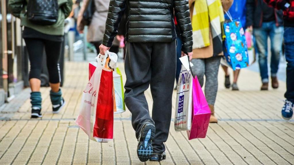 a man carrying bags in the Broadmead shopping area of Bristol