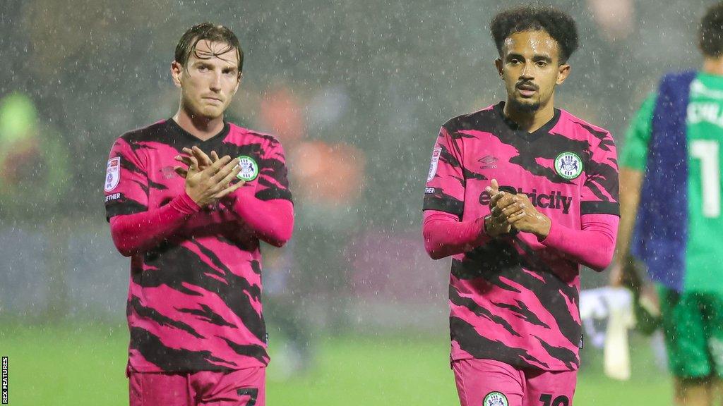 Forest Green players Kyle McAllister and Jacob Maddox clap fans during their match against Stockport