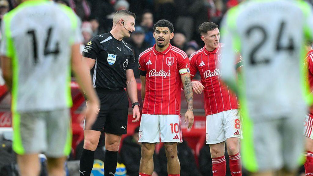 Referee Robert Jones speaks with Morgan Gibbs-White