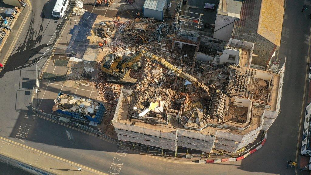 A digger at work demolishing the interior of the hotel