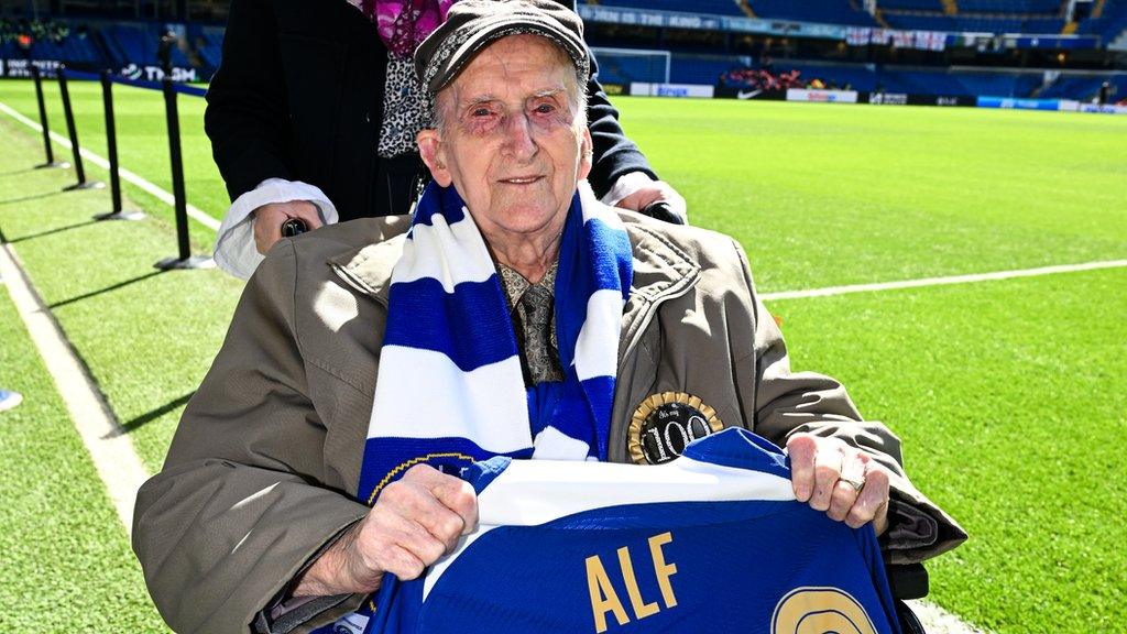 Alf Wells holding a Chelsea football shirt bearing his name