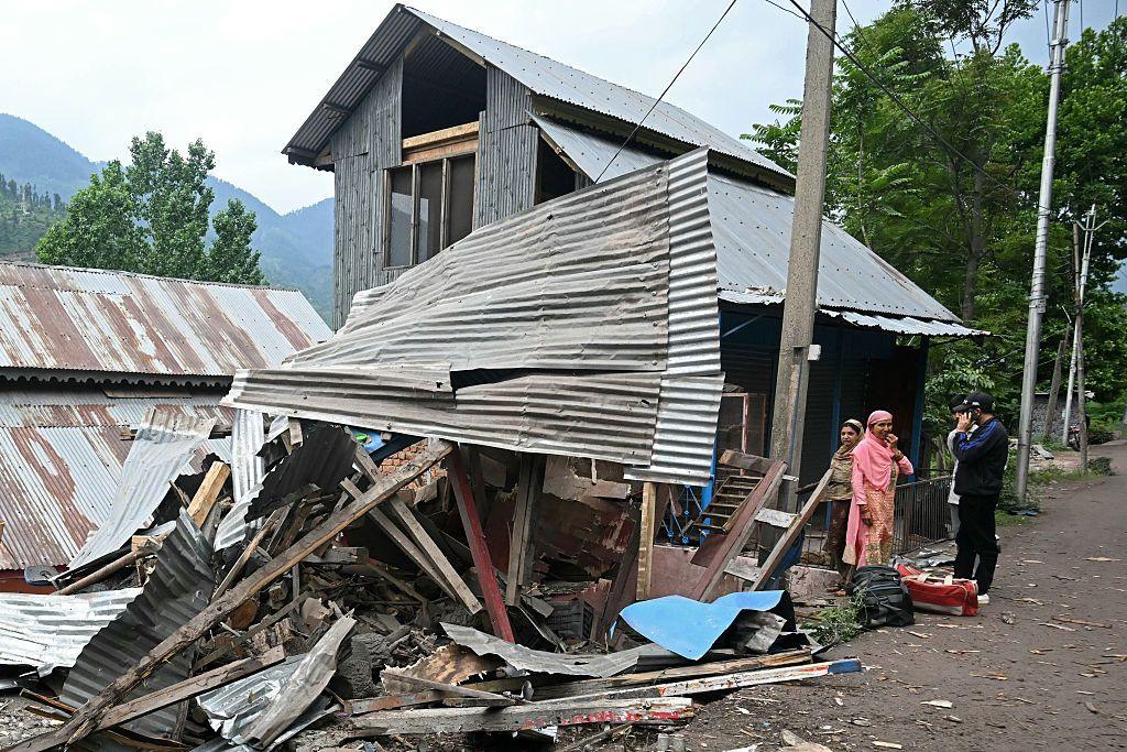 Local residents stand outside their house that was destroyed by Pakistani artillery shelling as they prepare to evacuate at the Lagama village in Uri, about 100kms from Srinagar, on May 9, 2025.