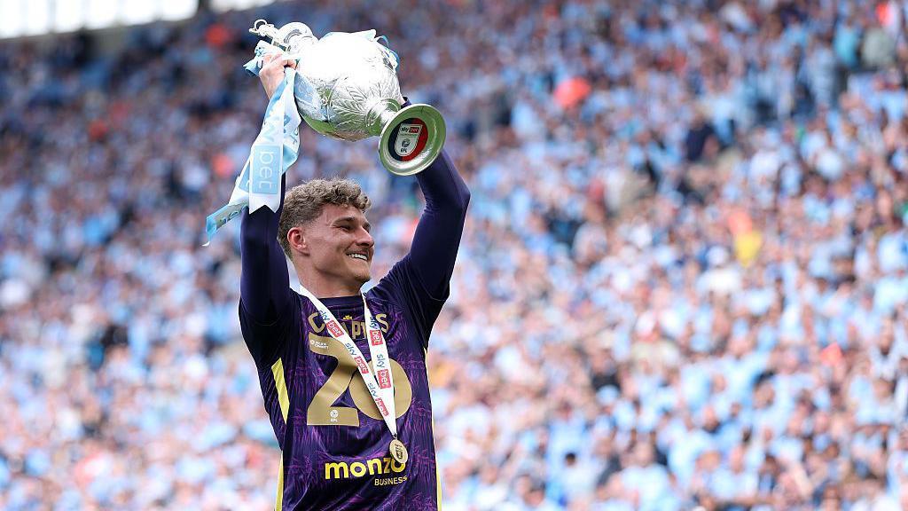 Carl Rushworth holds the Championship trophy aloft