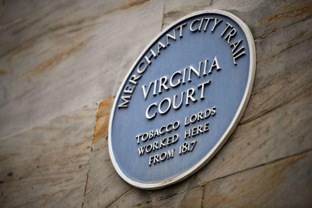 A sign on a sandstone building which reads "Merchant City Trail Virginia Court" and in smaller print, "tobacco lords worked here from 1817"