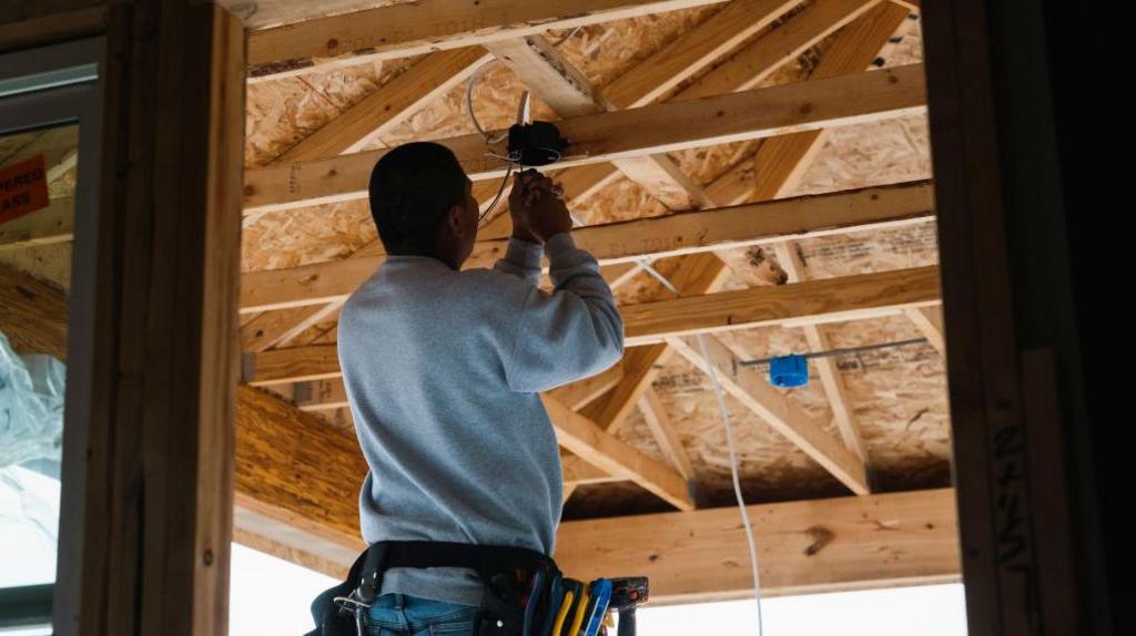  worker installs electrical wiring in a home under construction in Kyle, Texas, US, on Monday, March 18, 2024.