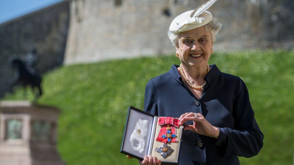 WINDSOR, ENGLAND - APRIL 15: Actress Angela Lansbury poses with her Dame Commander (DBE) medal given to her by Queen Elizabeth II at an Investiture ceremony at Windsor Castle on April 15, 2014 in Berkshire, England. (Photo by Steve Parsons - WPA Pool/Getty Images)