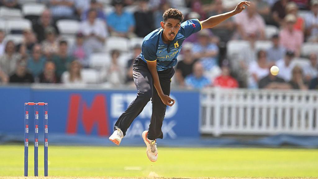 Tazeem Ali is in his follow through after sending down a leg-break in a One-Day Cup game for Warwickshire