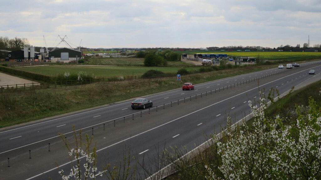 A428 with cars going up and down the dual carriageway with Bourn Airfield in the distance