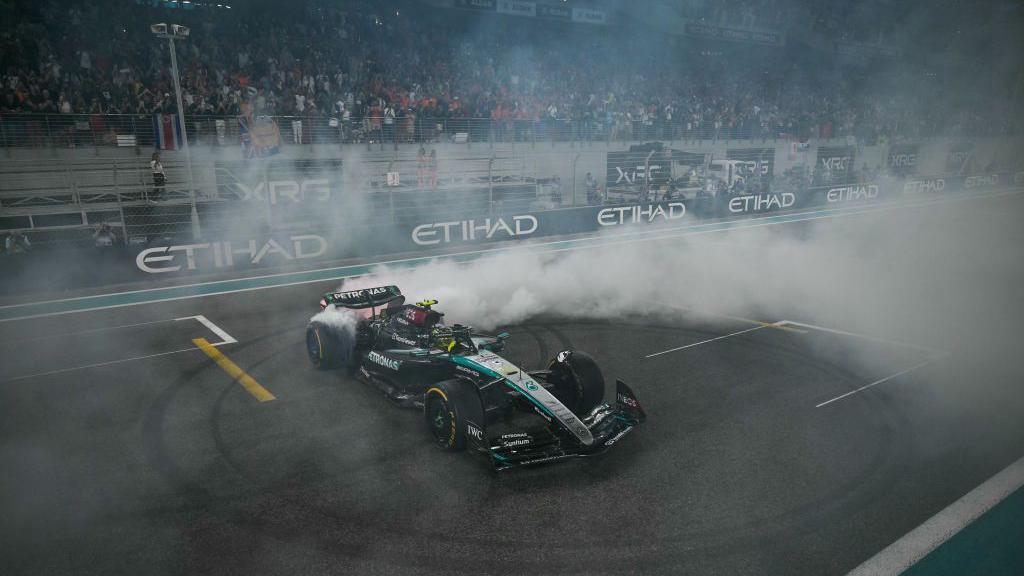 Lewis Hamilton does 'donuts' on the pit straight after finishing fourth in the Abu Dhabi Grand Prix in his final race for Mercedes