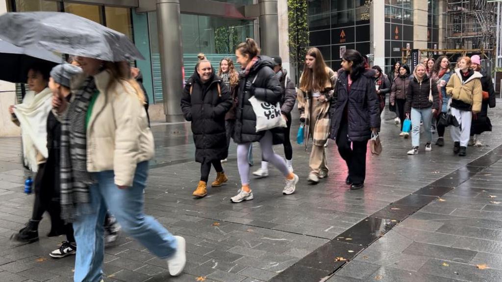 A group of people walking with umbrellas