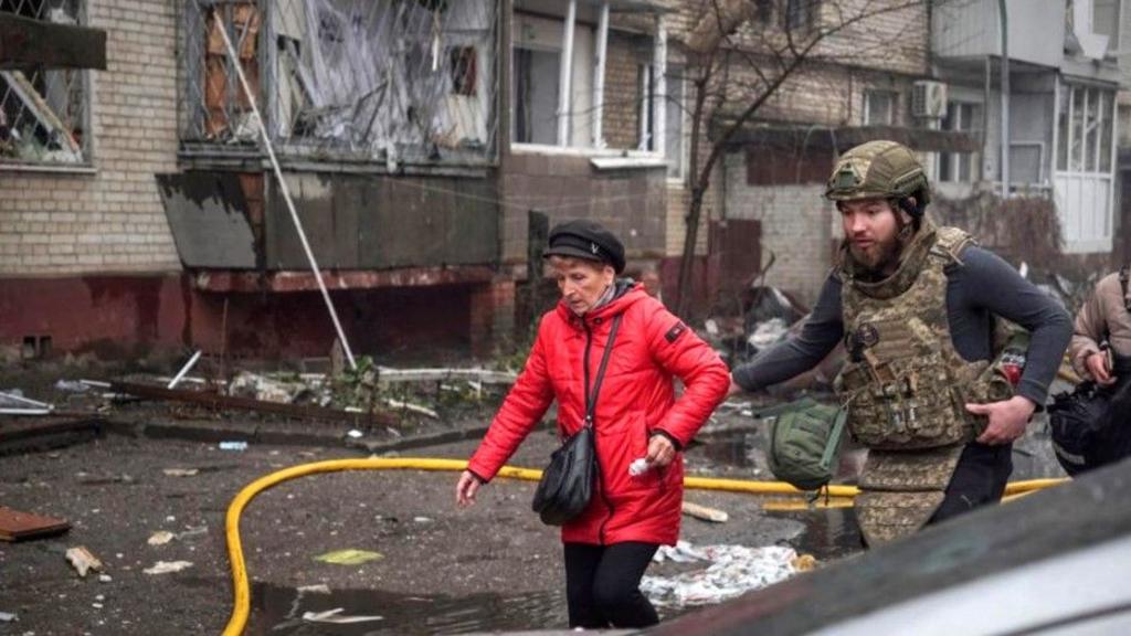 A Ukrainian serviceman evacuates a woman from an apartment building hit by a Russian missile strike, amid Russia's attack on Ukraine, in Sumy, Ukraine March 24, 2025