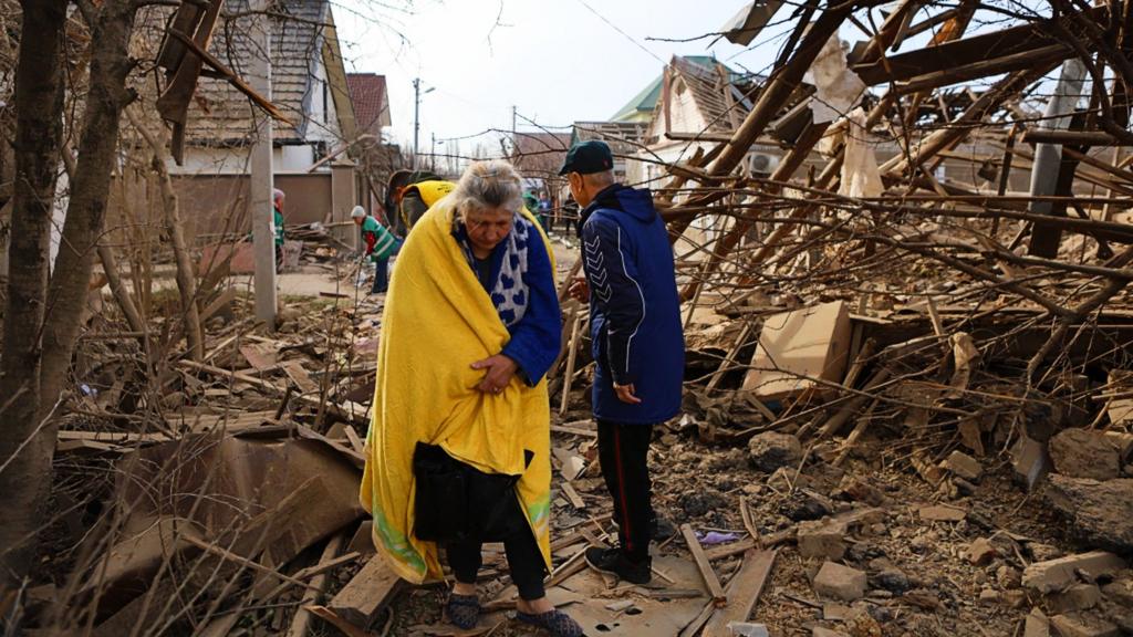 People walk amid debris at Central district after Russian attack with aerial guided bombs on March 15, 2025 in Kherson, Ukraine. Russian army carried out an airstrike on Kherson on the evening of March 14.