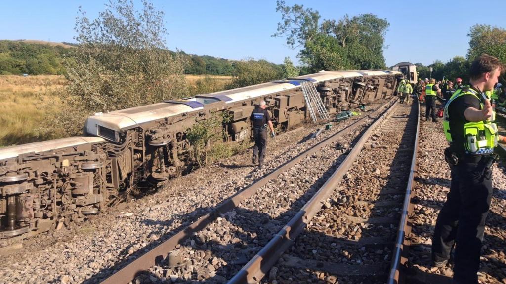 Emergency workers standing on railway tracks after a train derailed.