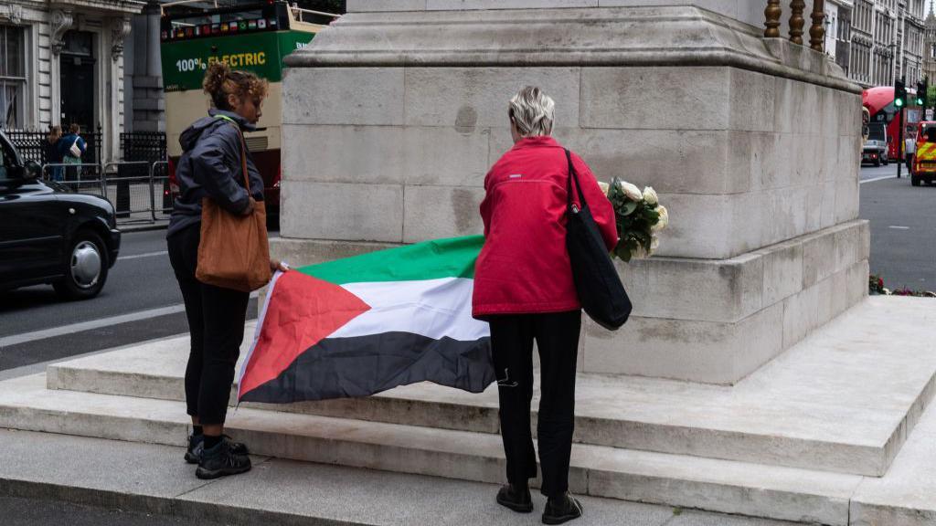 They laid flowers and a Palestinian flag on the memorial